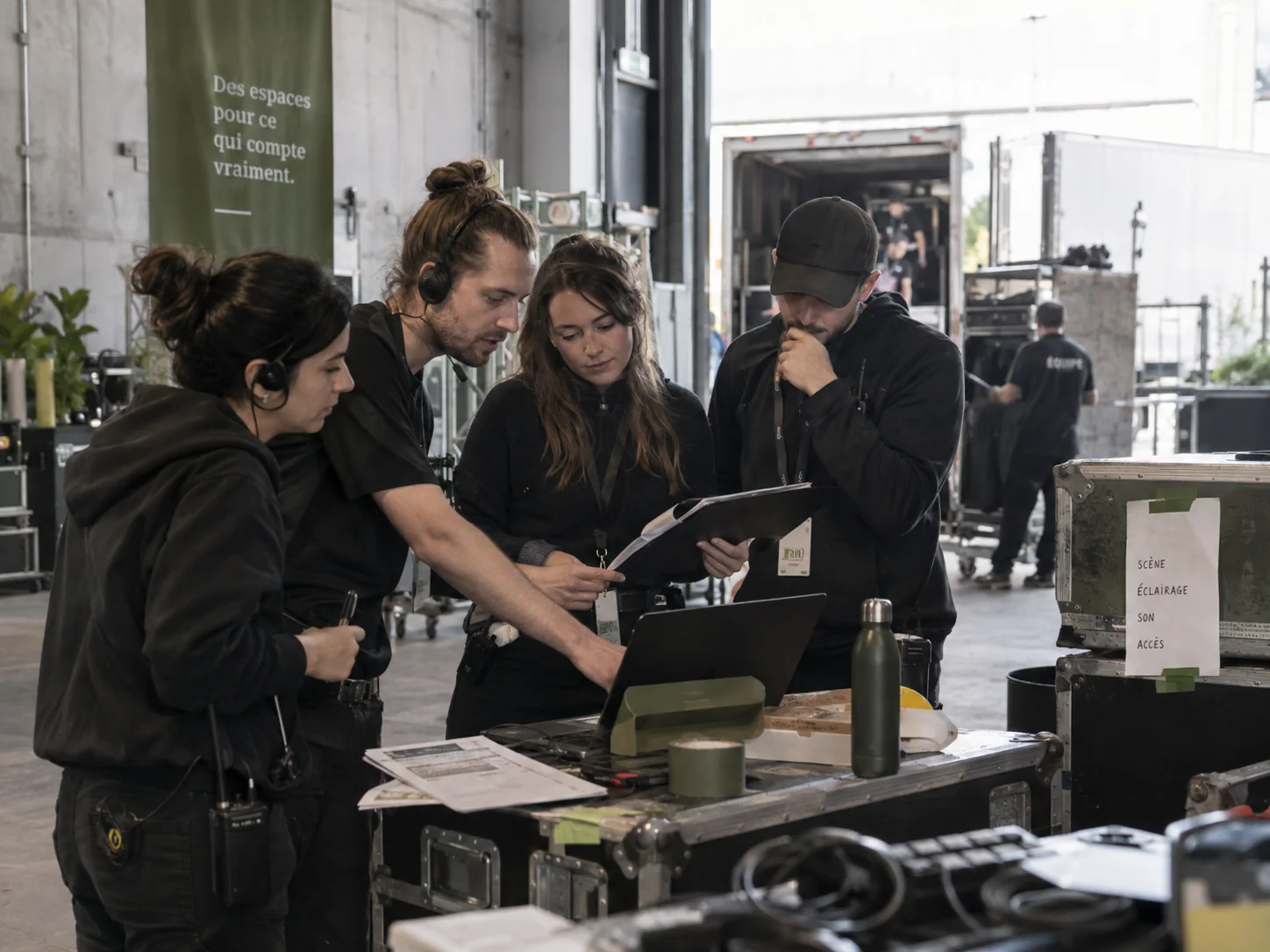 Une équipe de production coordonne un événement autour de son matériel et de ses documents.